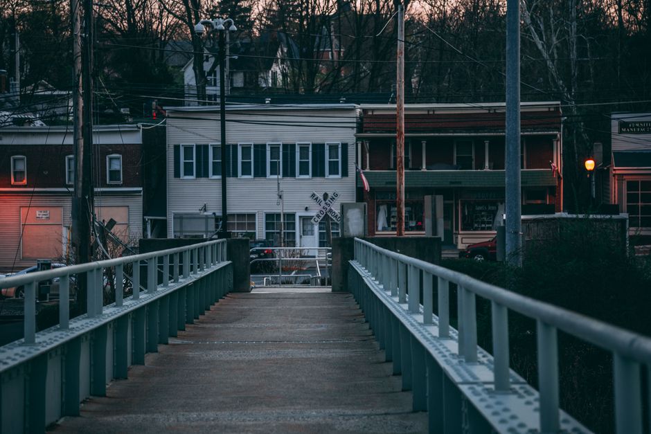 Atmospheric dusk view of a bridge leading to buildings in Portland, PA.