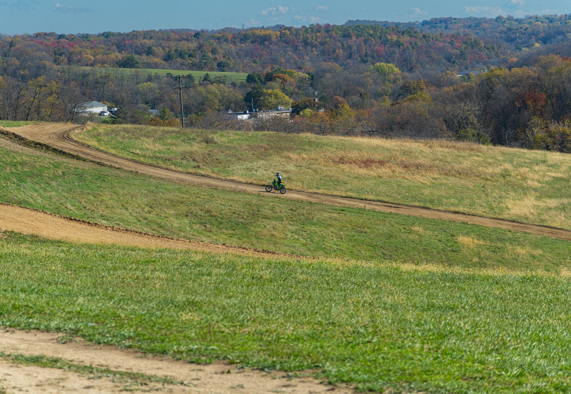 A dirt bike rider navigating a scenic trail in the autumn countryside of Cecil-Bishop, Pennsylvania.