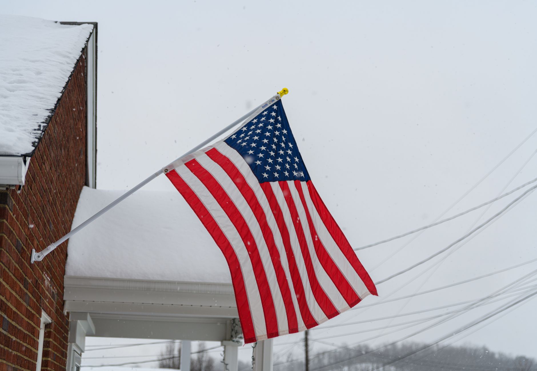 A snow-covered American flag displayed outdoors in Canonsburg, Pennsylvania during winter.